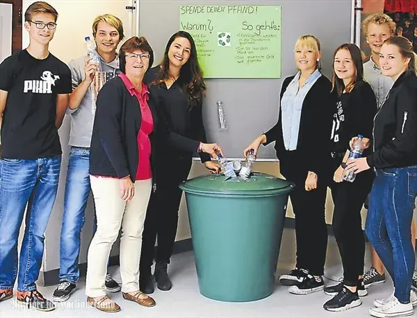 Schüler und Lehrer bei einer Pfand-Sammelaktion an einer Schule mit Sammeltonne